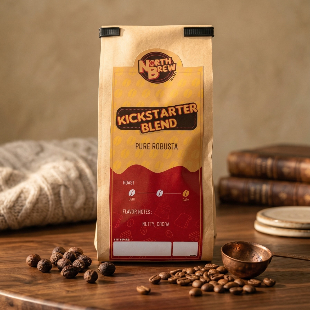 Brown coffee bag labeled "Kickstarter Blend" from North Brew, surrounded by scattered coffee beans on a wooden table.